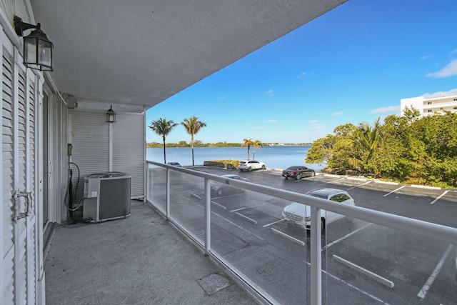 balcony with a water view and central air condition unit