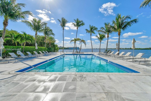 view of swimming pool with a patio and a water view