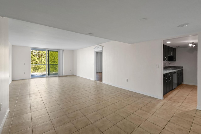 tiled empty room featuring sink and floor to ceiling windows