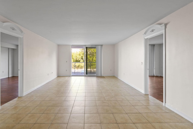 tiled empty room featuring floor to ceiling windows