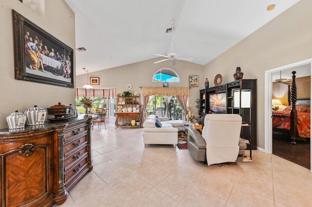 living room featuring ceiling fan, light tile patterned floors, and lofted ceiling