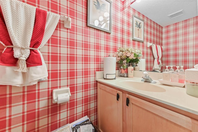 bathroom with a textured ceiling and vanity