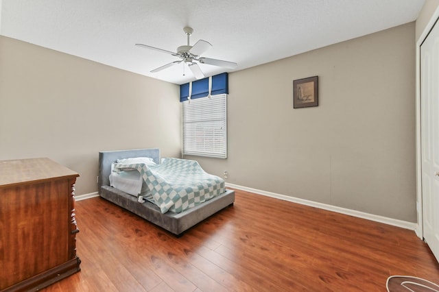 bedroom featuring a textured ceiling, ceiling fan, and wood-type flooring