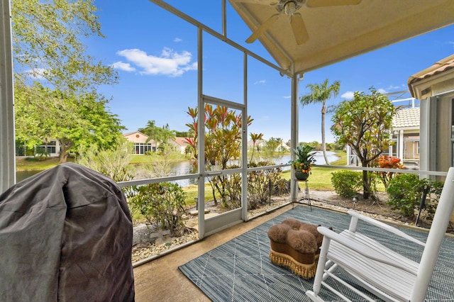 sunroom featuring ceiling fan, plenty of natural light, and a water view