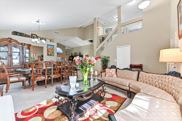 living room featuring high vaulted ceiling, light tile patterned floors, and ceiling fan with notable chandelier