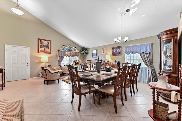 tiled dining space with lofted ceiling and an inviting chandelier