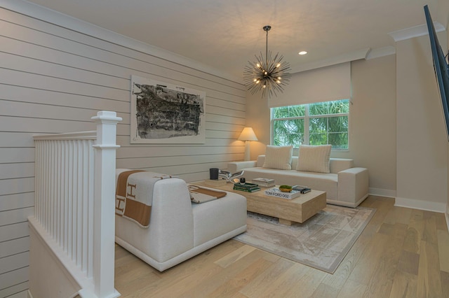 living room featuring light hardwood / wood-style flooring, ornamental molding, wooden walls, and an inviting chandelier