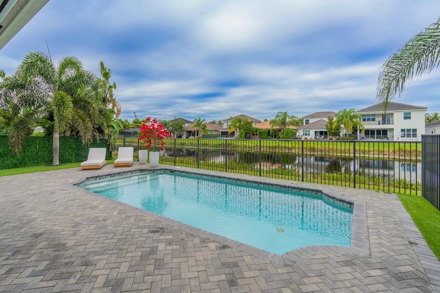 view of swimming pool featuring a water view and a patio