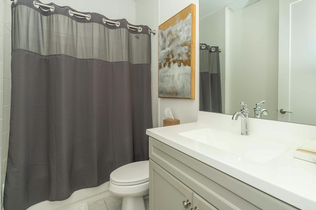 bathroom with toilet, vanity, and tile patterned flooring