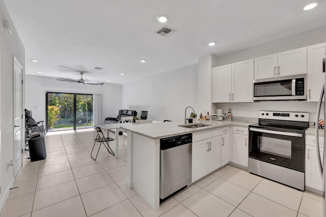 kitchen featuring kitchen peninsula, stainless steel appliances, white cabinets, and sink