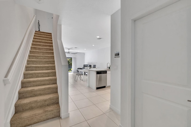 staircase featuring sink and tile patterned floors