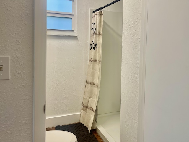 bathroom featuring toilet and walk in shower