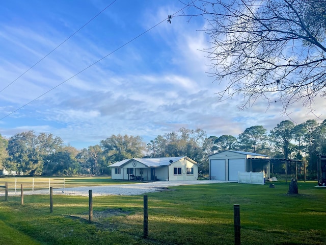 view of yard with a garage, an outbuilding, and a rural view