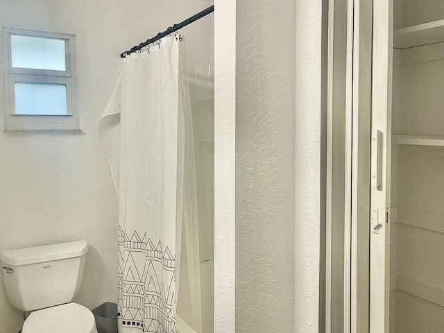 bathroom featuring toilet and a shower with shower curtain