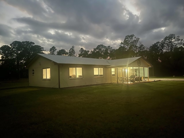 rear view of house featuring a lawn