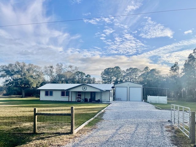 ranch-style house featuring a garage, a front yard, and an outbuilding