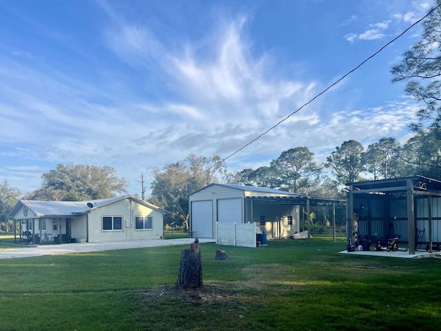 view of yard with a garage and an outbuilding