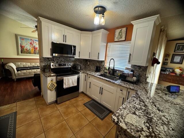 kitchen with stainless steel appliances, sink, and white cabinets