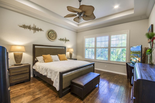 bedroom with dark hardwood / wood-style floors, ceiling fan, ornamental molding, and a raised ceiling