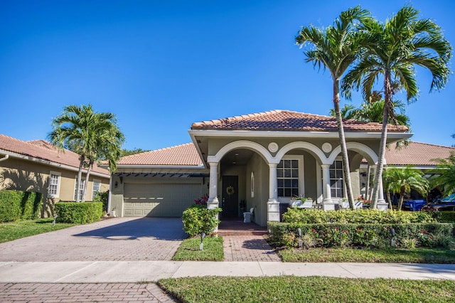 mediterranean / spanish-style house with a garage and a porch