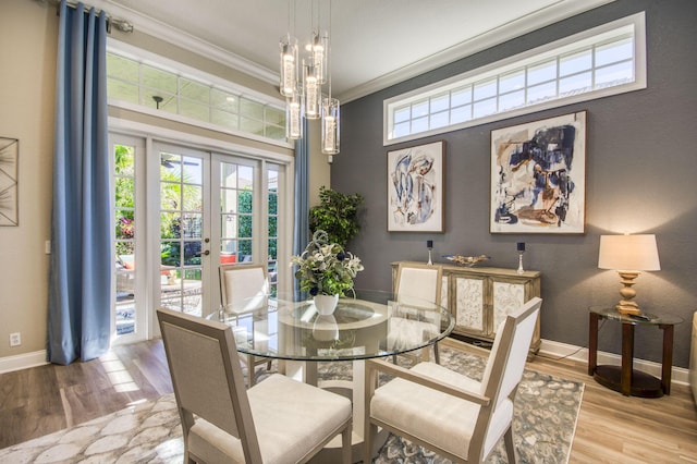 dining space featuring plenty of natural light, crown molding, french doors, and light wood-type flooring