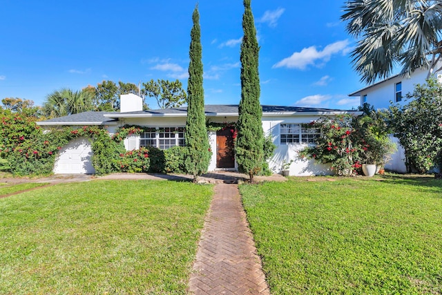 ranch-style home featuring a front lawn and a garage