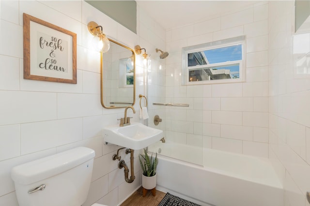 full bathroom featuring tiled shower / bath combo, hardwood / wood-style flooring, toilet, and sink