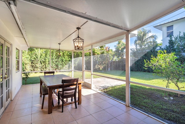 sunroom / solarium featuring an inviting chandelier