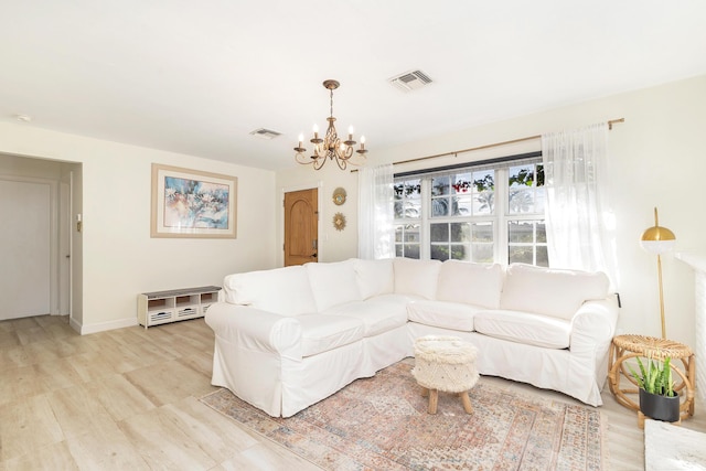 living room with light hardwood / wood-style flooring and an inviting chandelier