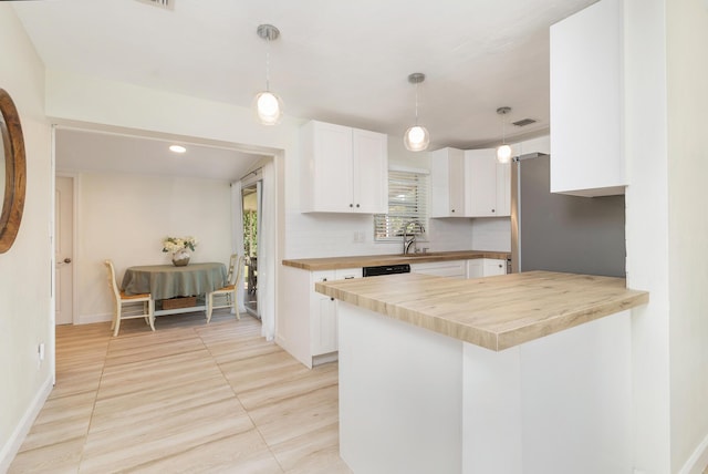 kitchen with kitchen peninsula, wooden counters, tasteful backsplash, light tile patterned floors, and white cabinetry