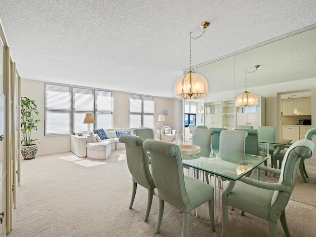 dining space featuring light colored carpet, a textured ceiling, and a chandelier