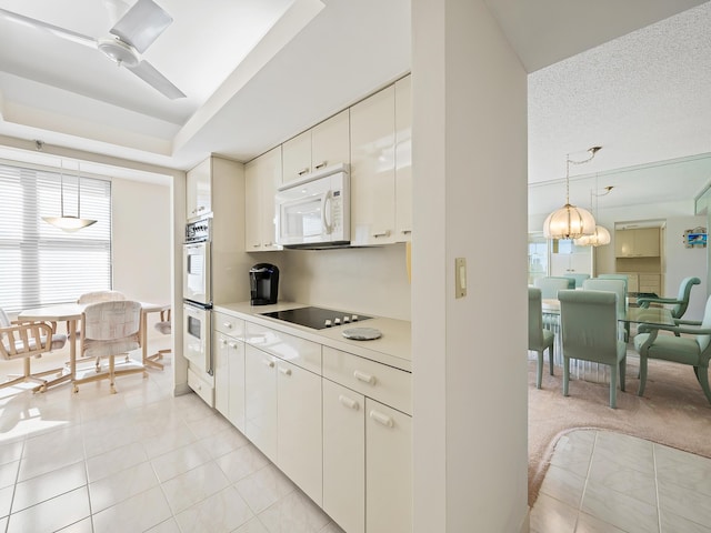 kitchen featuring white appliances, white cabinets, hanging light fixtures, ceiling fan, and light tile patterned floors