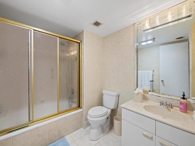 full bathroom featuring toilet, bath / shower combo with glass door, tile patterned flooring, and vanity