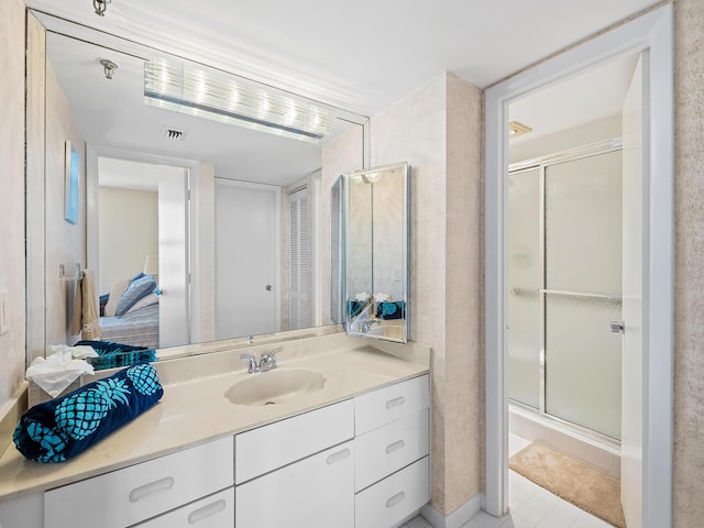 bathroom with vanity and a shower with door