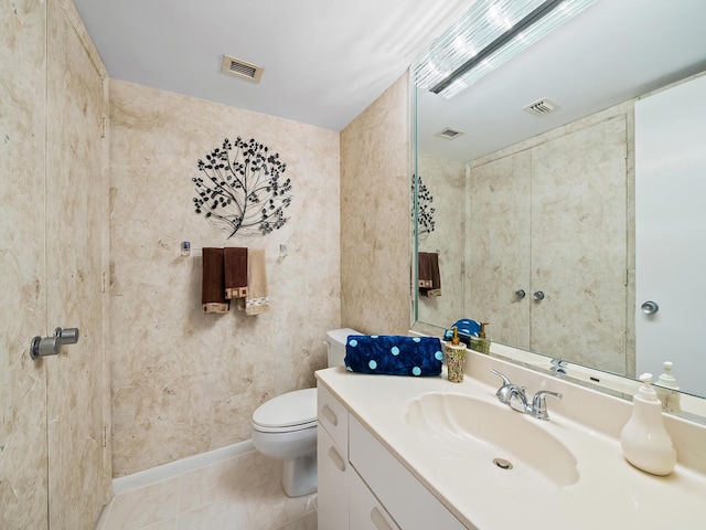 bathroom with toilet, tile patterned floors, and vanity