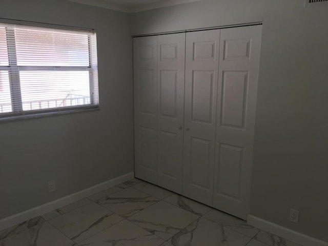 unfurnished bedroom with multiple windows and a closet