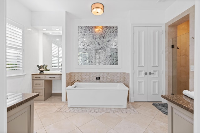 bathroom featuring tile patterned flooring, vanity, and separate shower and tub