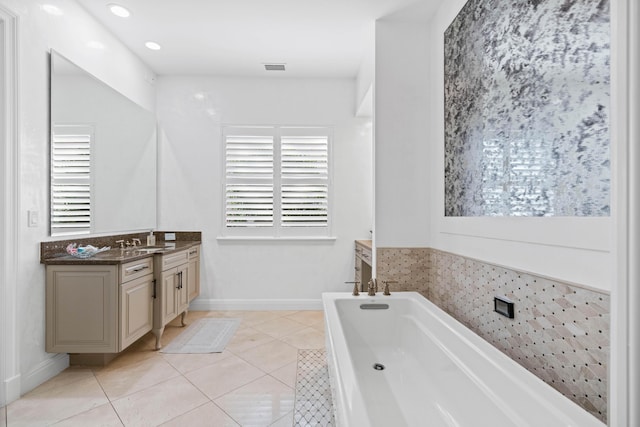 bathroom with tile patterned floors, a bathtub, and vanity