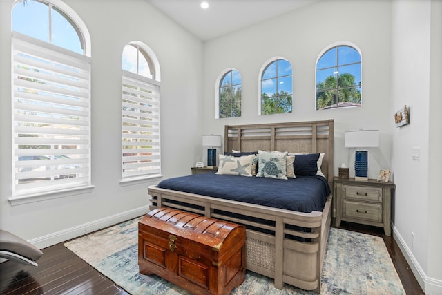 bedroom featuring dark hardwood / wood-style floors, vaulted ceiling, and multiple windows