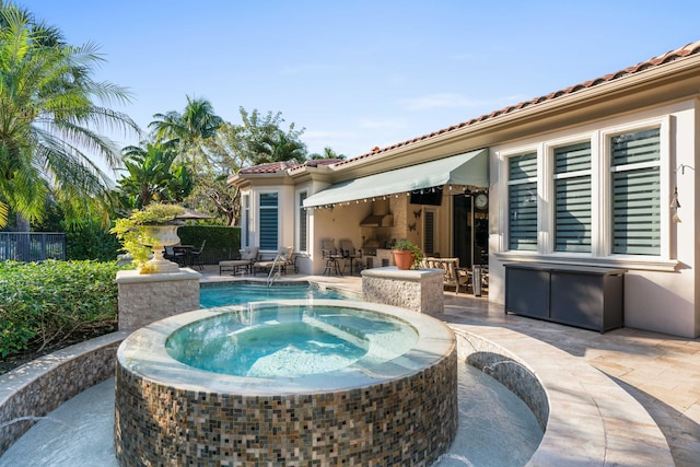 view of pool featuring an in ground hot tub, pool water feature, and a patio