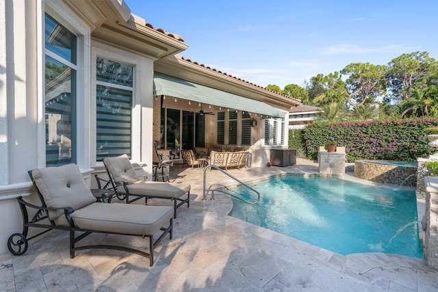 view of swimming pool featuring pool water feature and a patio area