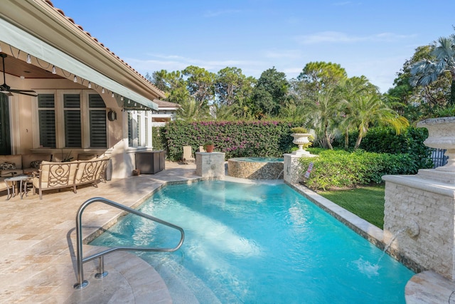 view of swimming pool with pool water feature, outdoor lounge area, and a patio