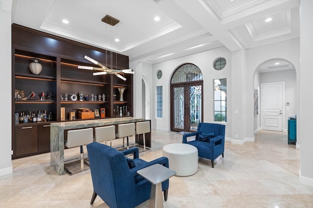 living room featuring bar area, crown molding, french doors, and beam ceiling