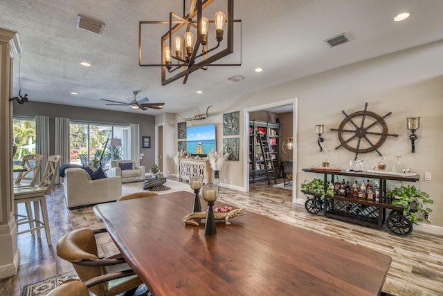 dining space featuring ceiling fan, hardwood / wood-style floors, and a textured ceiling