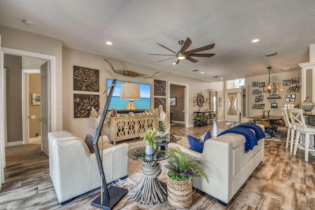 living room with ceiling fan and a textured ceiling