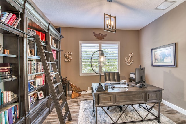 office area with hardwood / wood-style flooring, a notable chandelier, and a textured ceiling