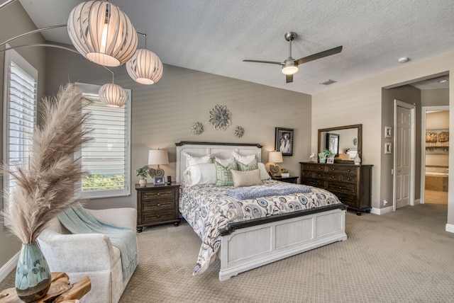 bedroom featuring light carpet, a textured ceiling, ensuite bathroom, and ceiling fan