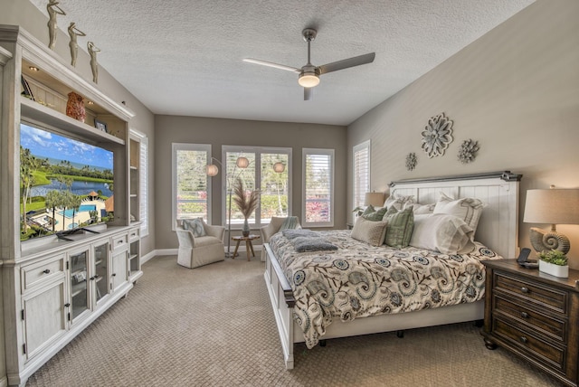 bedroom featuring light carpet, a textured ceiling, and ceiling fan