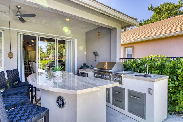 view of patio featuring an outdoor kitchen, ceiling fan, a grill, and a wet bar