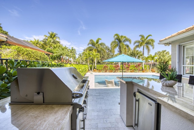 view of patio featuring exterior kitchen and grilling area